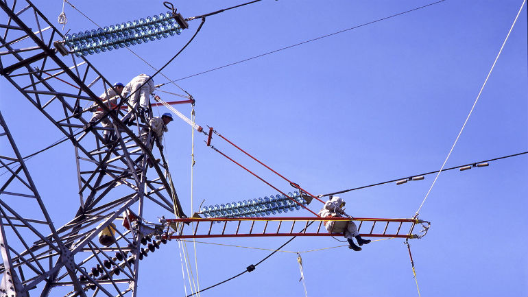 Imagen de un operario haciendo labores de mantenimiento en una torre de electricidad