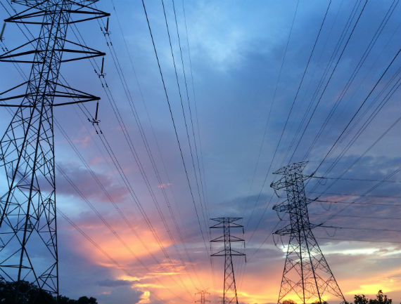 Tres torres de distribución eléctrica de alta tensión en un paisaje abierto y despejado